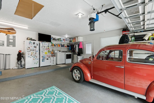 garage featuring white fridge, washing machine and clothes dryer, and electric panel