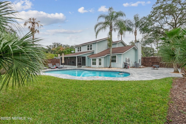 view of swimming pool with a patio area, a yard, a sunroom, and central AC