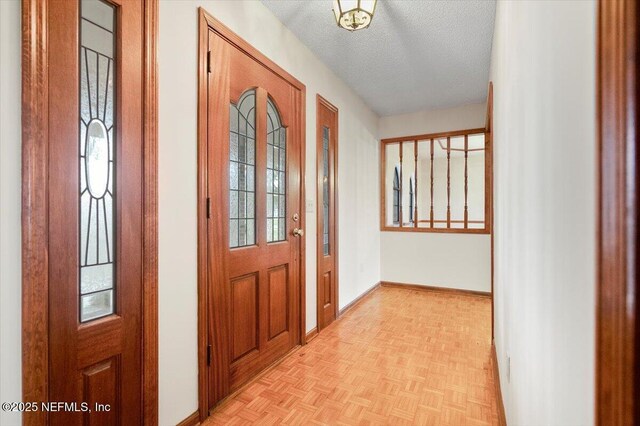 entryway featuring a textured ceiling and light parquet flooring