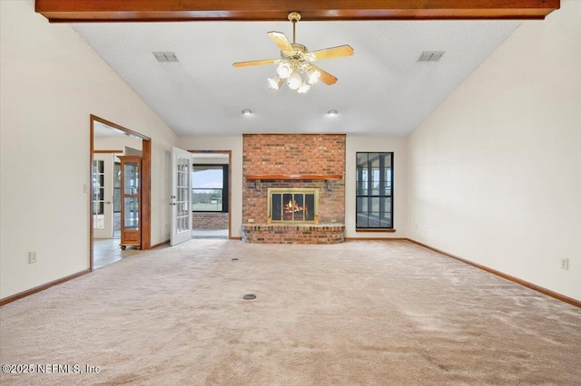 unfurnished living room with a brick fireplace, beam ceiling, high vaulted ceiling, and carpet flooring