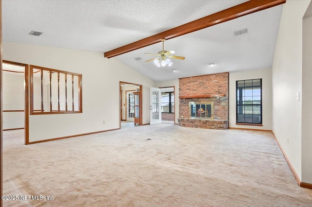 unfurnished living room featuring lofted ceiling with beams, ceiling fan, a brick fireplace, light carpet, and a textured ceiling