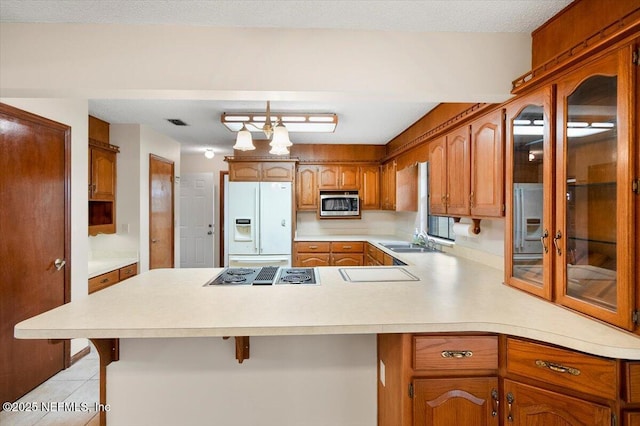 kitchen featuring appliances with stainless steel finishes, pendant lighting, sink, a breakfast bar area, and kitchen peninsula