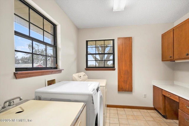 laundry room featuring cabinets, sink, a textured ceiling, and washer and clothes dryer