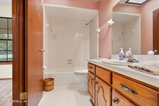 full bathroom featuring tiled shower / bath, vanity, toilet, and a skylight