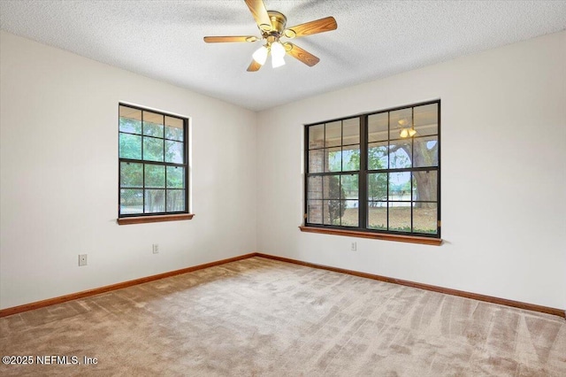 carpeted empty room with ceiling fan and a textured ceiling