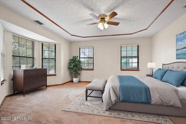 bedroom with ceiling fan, a raised ceiling, light carpet, and a textured ceiling