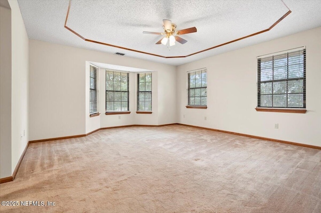 carpeted empty room with ceiling fan and a textured ceiling