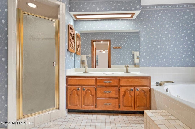 bathroom with tile patterned flooring, vanity, a skylight, and shower with separate bathtub