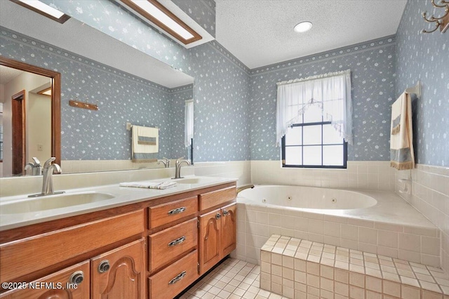 bathroom featuring tile patterned floors, vanity, a textured ceiling, and tiled tub