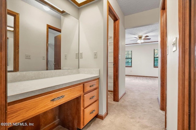 bathroom with vanity, ceiling fan, and a textured ceiling