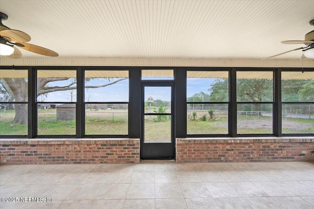 unfurnished sunroom with a healthy amount of sunlight and ceiling fan