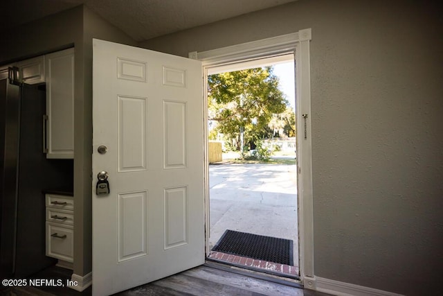 entryway with dark hardwood / wood-style flooring and vaulted ceiling