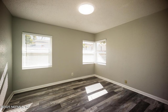 unfurnished room with a textured ceiling and dark hardwood / wood-style floors