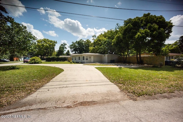 view of front of home featuring a front lawn and curved driveway