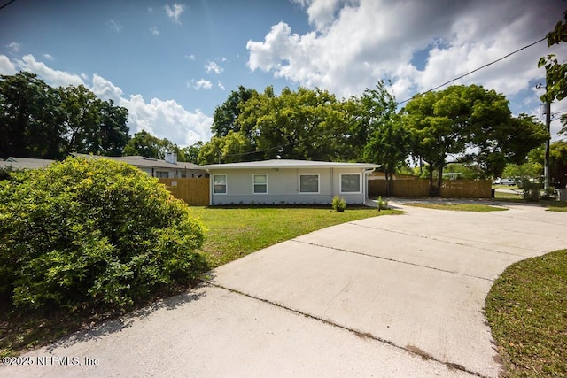 single story home featuring a front yard, fence, and concrete driveway