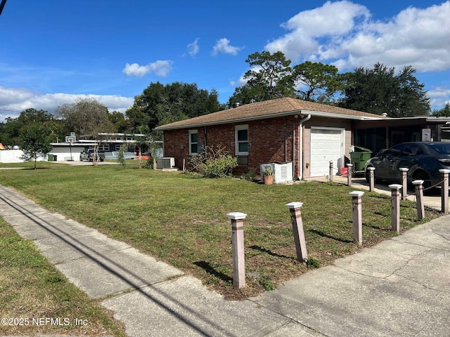 view of front facade featuring a garage, a front yard, and central AC