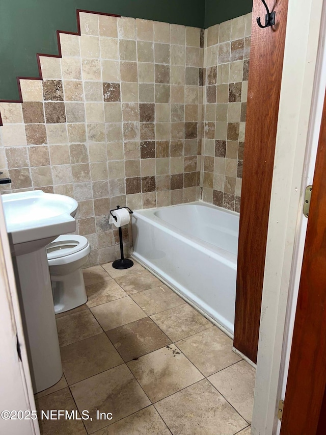 bathroom featuring tile walls and toilet