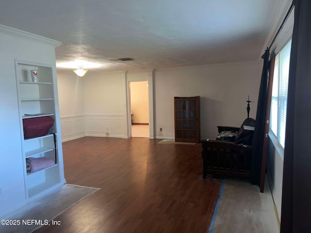 living room with built in shelves, crown molding, and hardwood / wood-style floors