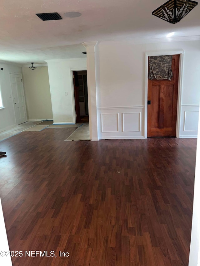 unfurnished room featuring dark wood-type flooring and ornamental molding