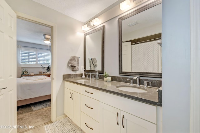 bathroom with a textured ceiling, walk in shower, and vanity