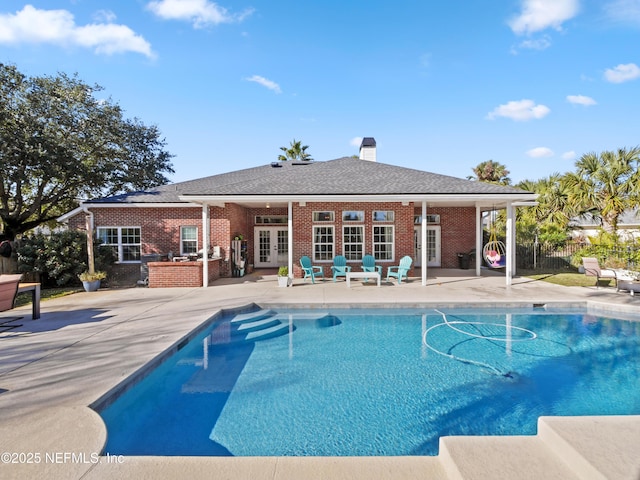 view of swimming pool featuring a patio area and french doors