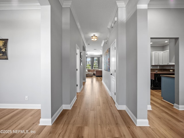 hall featuring ornamental molding, light hardwood / wood-style floors, and a textured ceiling