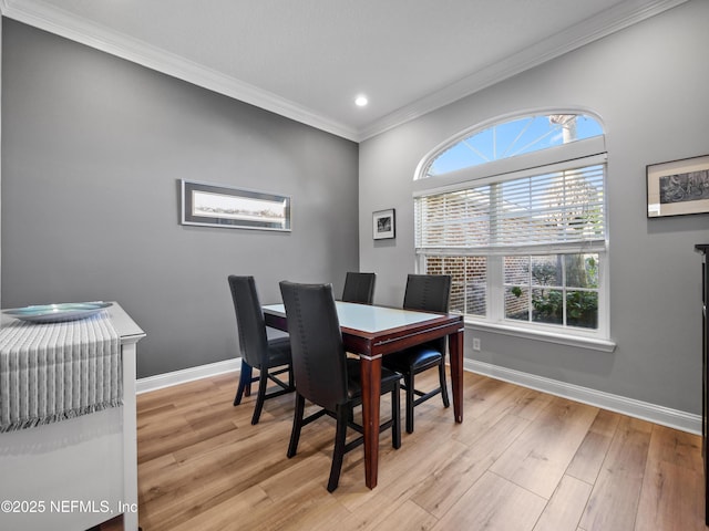 dining area with crown molding and light hardwood / wood-style flooring