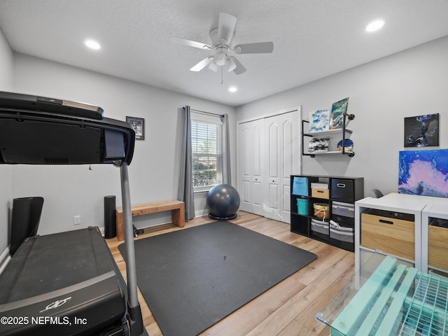 workout area with hardwood / wood-style flooring, ceiling fan, and a textured ceiling