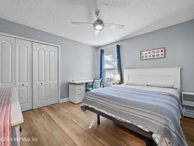 bedroom featuring a textured ceiling, a closet, ceiling fan, and light wood-type flooring