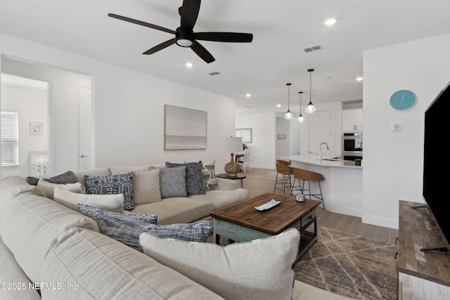 living room featuring ceiling fan and sink