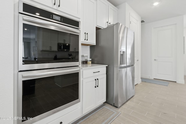 kitchen featuring stainless steel appliances and white cabinetry