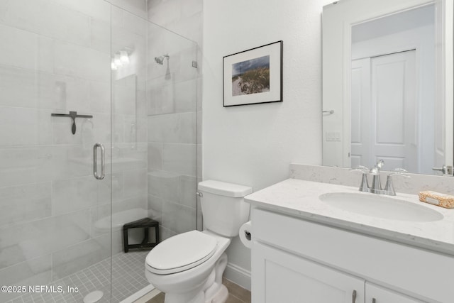 bathroom with walk in shower, vanity, and toilet