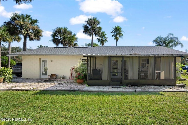 back of property featuring a yard and a sunroom