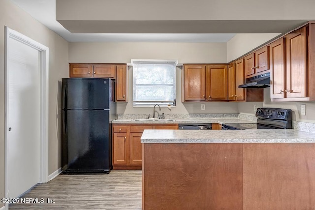 kitchen with black appliances, light wood-type flooring, sink, and kitchen peninsula