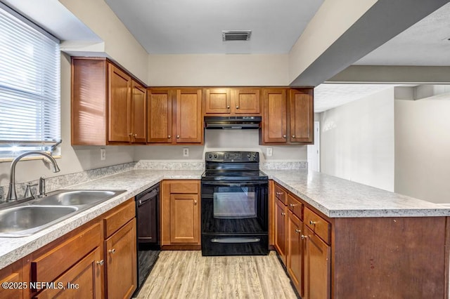 kitchen with sink, black appliances, and light wood-type flooring