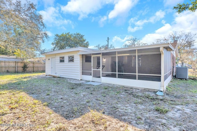 rear view of property with central AC, a yard, and a sunroom