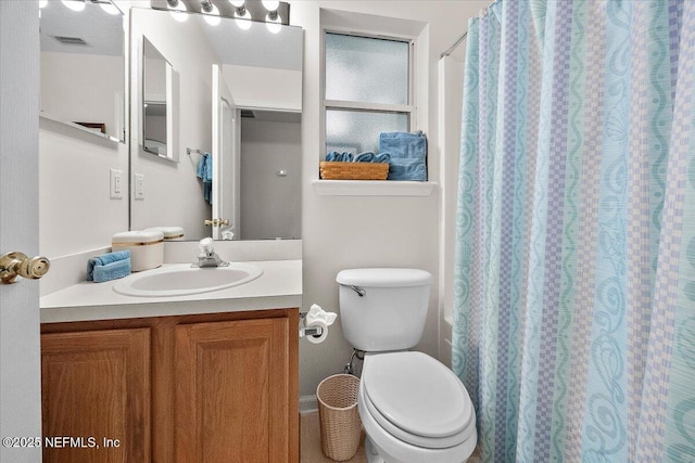 bathroom with toilet, vanity, and a shower with shower curtain