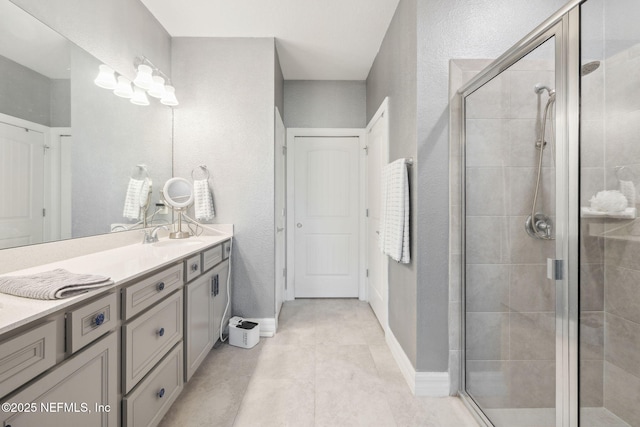 bathroom with vanity, tile patterned flooring, and a shower with door