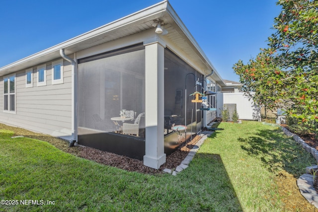 view of home's exterior featuring a sunroom and a yard