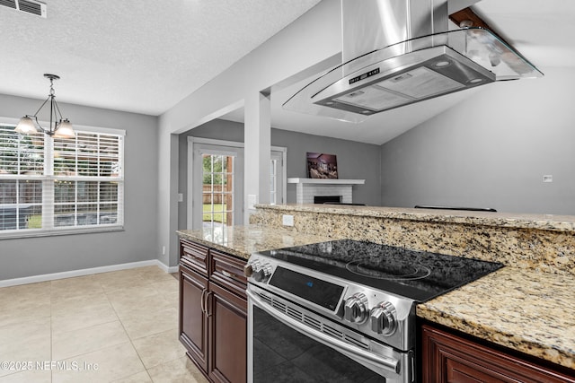 kitchen featuring light stone counters, electric range, a textured ceiling, and a fireplace