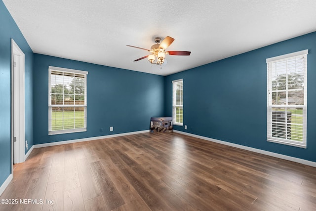 spare room with a textured ceiling, dark hardwood / wood-style floors, and ceiling fan