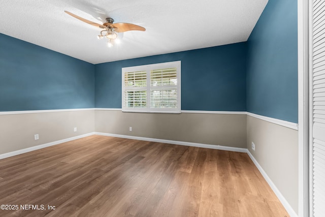 unfurnished room featuring ceiling fan, hardwood / wood-style floors, and a textured ceiling