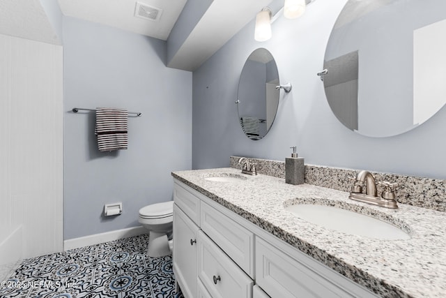 bathroom featuring vanity, toilet, and tile patterned flooring