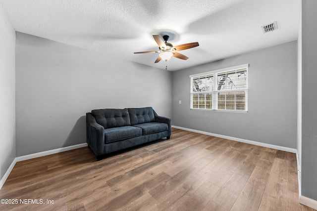 sitting room featuring hardwood / wood-style flooring, a textured ceiling, and ceiling fan