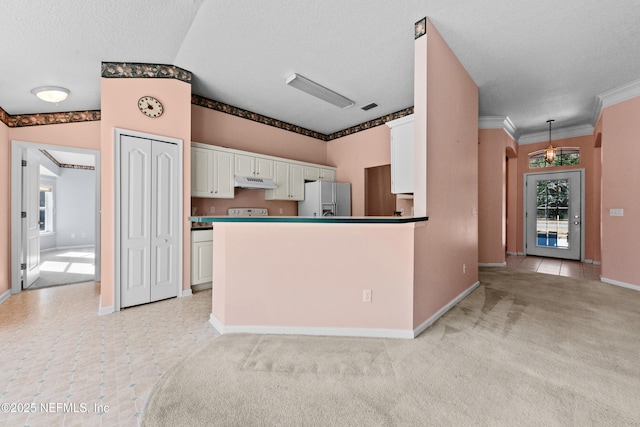 kitchen featuring hanging light fixtures, white cabinetry, a textured ceiling, and stainless steel fridge with ice dispenser