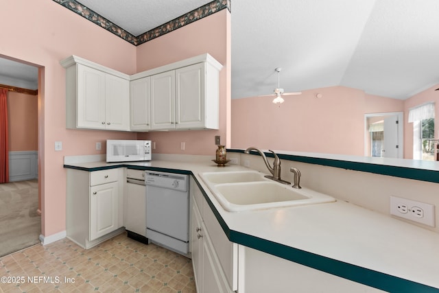 kitchen with white appliances, lofted ceiling, sink, and white cabinets