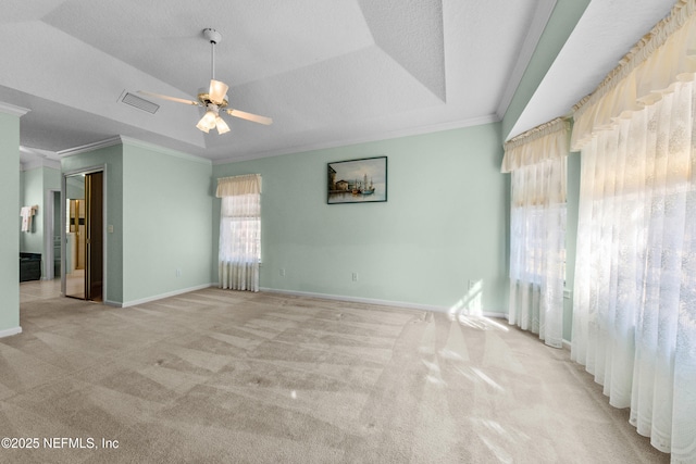 carpeted spare room featuring ornamental molding, ceiling fan, and a tray ceiling