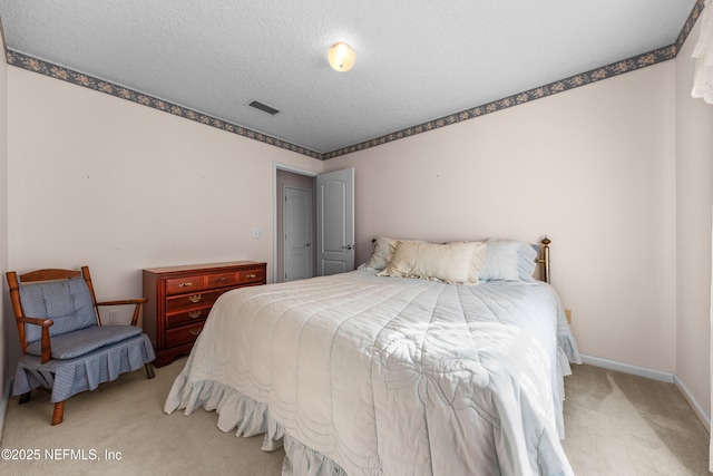 bedroom featuring light carpet and a textured ceiling