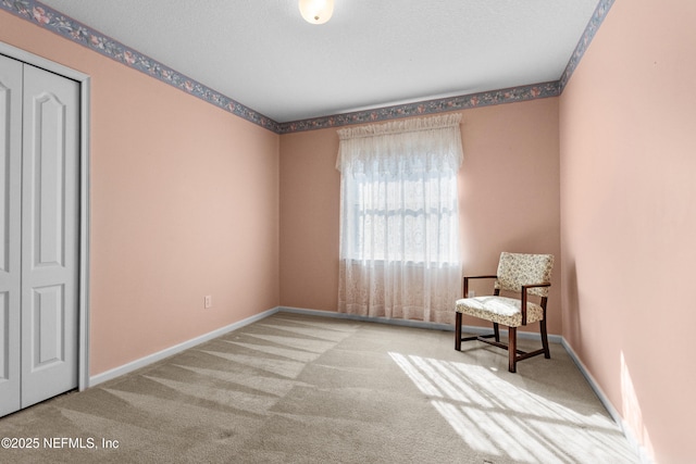 living area with light colored carpet and a textured ceiling