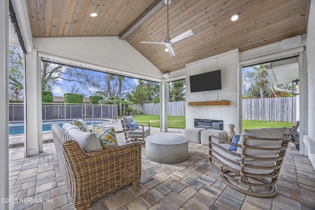 view of patio / terrace featuring ceiling fan, an outdoor living space with a fireplace, and a fenced in pool